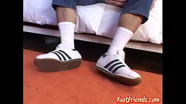 Lindo semental juega suavemente con sus pies y se lame los dedos