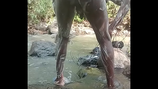 Chico con gran polla negra se masturba mientras se ducha al aire libre y dispara una gran carga